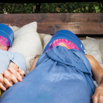 Couple relaxing while receiving LED light therapy treatment with a Celluma Lite Series 2 Therapy Face Mask Outdoors